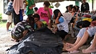 Personas rodean una bolsa para cadáveres en la ciudad de Bogo tras el seísmo del 30 de septiembre.