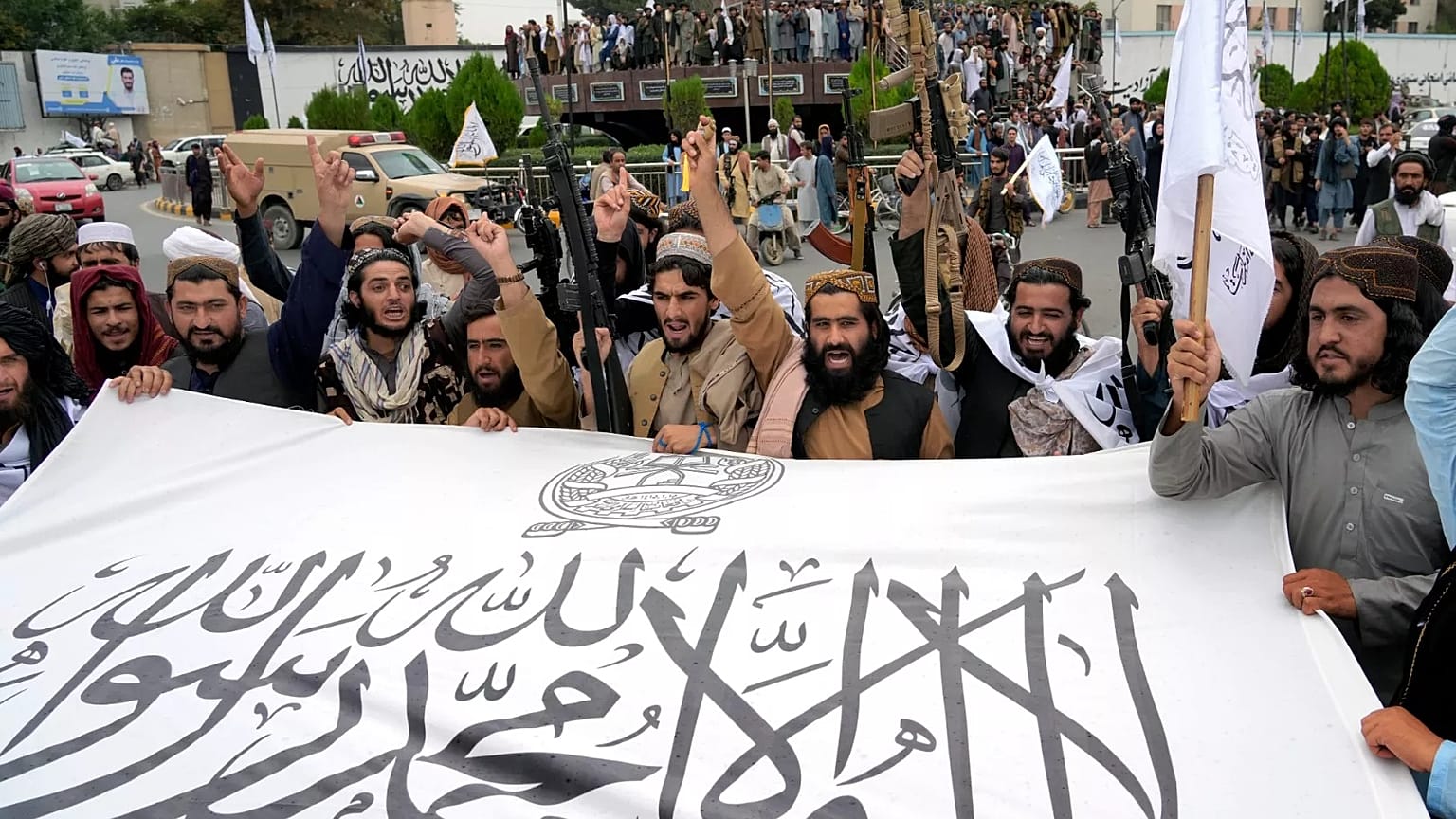 Taliban fighters hold their flag as they celebrate one year since they seized the Afghan capital Kabul, 15 August, 2022