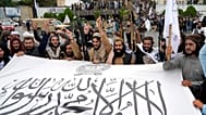 Taliban fighters hold their flag as they celebrate one year since they seized the Afghan capital Kabul, 15 August, 2022