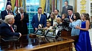 President Donald Trump listens to children who have survived cancer as he speaks in the Oval Office of the White House. 