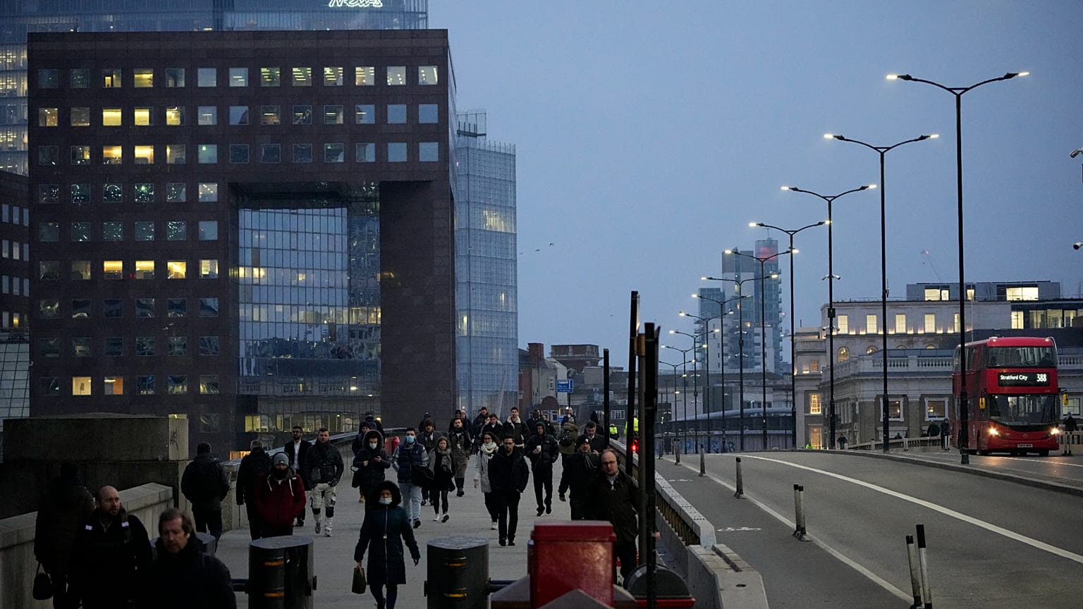 Workers walk over London Bridge towards the City of London financial district during the morning commute, in London. 24. Jan 2022.