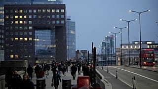 Εργαζόμενοι περπατούν πάνω από τη γέφυρα του Λονδίνου προς την οικονομική περιοχή City of London κατά τη διάρκεια της πρωινής μετακίνησης, στο Λονδίνο. 24. Ιαν. 2022.