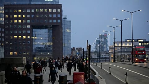 Workers walk over London Bridge towards the City of London financial district during the morning commute, in London. 24. Jan 2022.