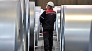 Almanya'nın Duisburg kentindeki Thyssenkrupp çelik fabrikasında bir işçi çelik bobinleri kontrol ediyor, 27 Nisan 2018.