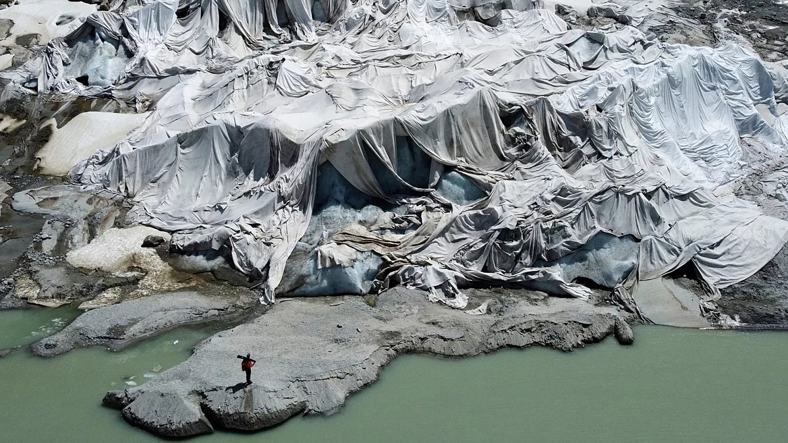  Matthias Huss, of the Federal Institute of Technology in Zurich and glacier monitoring group GLAMOS, stands at the Rhone Glacier that is partially covered with sheets.