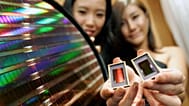 Employees of Samsung Electronics show the world's first 30-nanometre 64-gigabit NAND flash memory device during a news conference in Seoul, South Korea. October 2007.