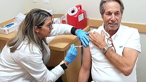 Daniel Toccin recibe una inyección de la vacuna COVID-19 mientras él y su esposa se vacunan contra el coronavirus y la gripe estacional para un próximo viaje en Miami, 9 de septiembre de 2025.
