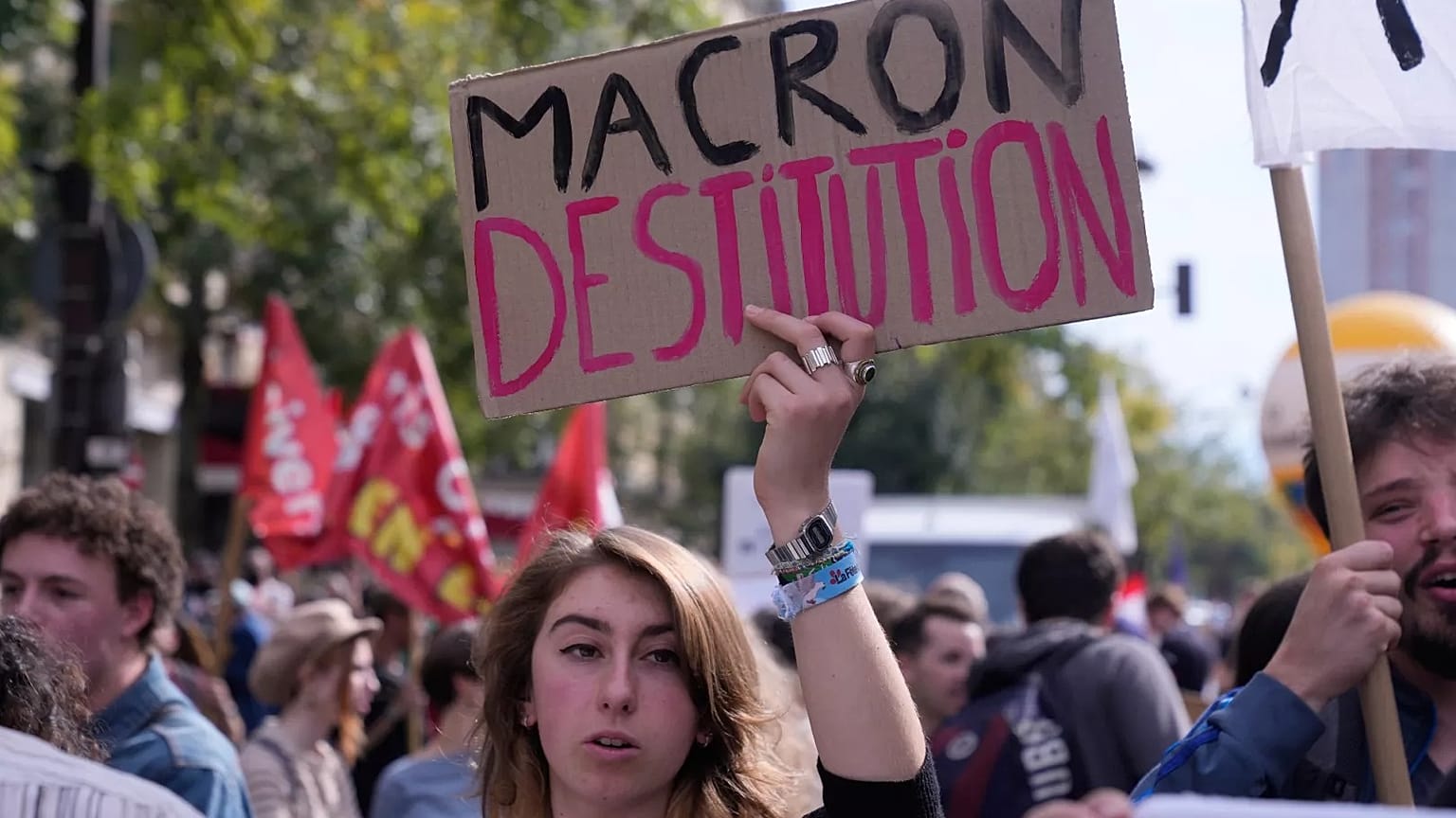 Una manifestante pide la dimisión de Emmanuel Macron, presidente de Francia, durante la tercera jornada de protestas en un mes contra los recortes, el 2 de octubre en París