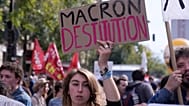 Una manifestante pide la dimisión de Emmanuel Macron, presidente de Francia, durante la tercera jornada de protestas en un mes contra los recortes, el 2 de octubre en París