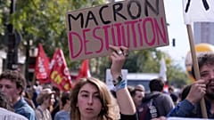 Una manifestante pide la dimisión de Emmanuel Macron, presidente de Francia, durante la tercera jornada de protestas en un mes contra los recortes, el 2 de octubre en París