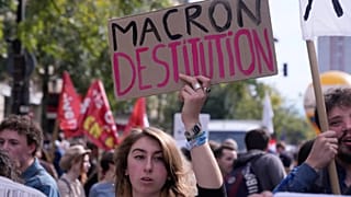 Una manifestante pide la dimisión de Emmanuel Macron, presidente de Francia, durante la tercera jornada de protestas en un mes contra los recortes, el 2 de octubre en París