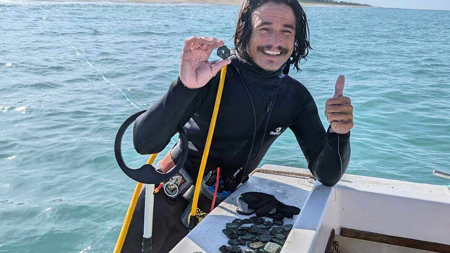 En esta fotografía sin fecha proporcionada por la empresa de salvamento de naufragios 1715 Fleet-Queens Jewels, LLC, el buzo Levin Shavers muestra monedas descubiertas.