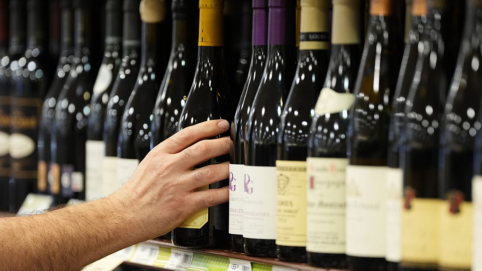 A clerk stocks French wines at Pennsylvania Fine Wine & Good Spirits in Flourtown, Pa. March 2025. 
