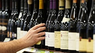 A clerk stocks French wines at Pennsylvania Fine Wine & Good Spirits in Flourtown, Pa. March 2025. 