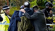 Members of the Jewish community comfort each other near to the Heaton Park Hebrew Congregation synagogue in Manchester, 2 October, 2025