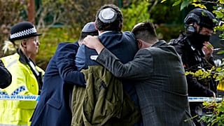 Members of the Jewish community comfort each other near to the Heaton Park Hebrew Congregation synagogue in Manchester, 2 October, 2025
