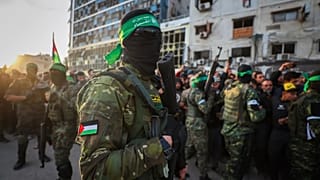 Fighters from Hamas control the crowd while the Red Cross collects Israeli hostages in Gaza City, 19 January, 2025