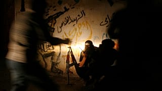 مسلّح فلسطيني من كتائب القسام، الجناح العسكري لحركة حماس، يتحدث عبر جهاز لاسلكي أثناء تأمين المنطقة في مخيم رفح للاجئين جنوب قطاع غزة، فجر الأحد 21 آب/أغسطس 2011. 