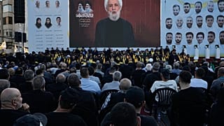 يستمع الناس إلى زعيم حزب الله نعيم قاسم وهو يلقي خطابًا متلفزًا خلال الذكرى الأولى لاغتيال حسن نصر الله، عند قبر نصر الله في بيروت، لبنان، السبت 27 سبتمبر 2025.