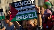Un manifestante pro-palestino sostiene una pancarta que dice: "Boicot al apartheid israelí" durante una protesta en Madrid, España, el 4 de octubre de 2025.