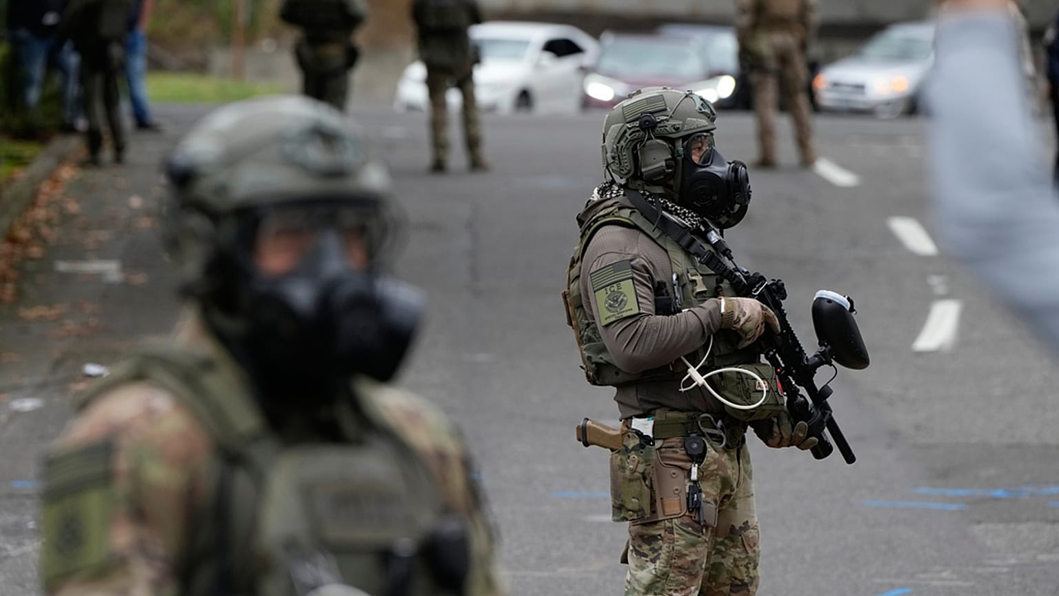 Immigration and Customs Enforcement agents stand outside an ICE facility during a protest on Saturday, Oct. 4, 2025, in Portland, Ore. (AP Photo/Jenny Kane)