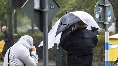 People struggle against the wind and rain in Malmö, Sweden, after a storm reached southern Sweden, Saturday Oct. 4, 2025. (Johan Nilsson/TT via AP)