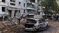 Burned cars and damaged residential building are seen after a Russian strike in Zaporizhzhia, Ukraine, Sunday, Oct. 5, 2025.