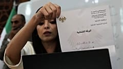 Сотрудник сирийской избирательной комиссии показывает бюллетень во время подсчета голосов, вскоре после закрытия избирательных участков в здании губернатора Латакии, воскресенье, 5 октября 2025 г.