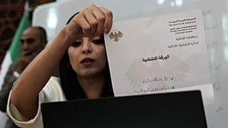 A Syrian election official shows a ballot paper during the counting of ballots, shortly after polling stations closed at Latakia's Governor building, Sunday, Oct. 5, 2025