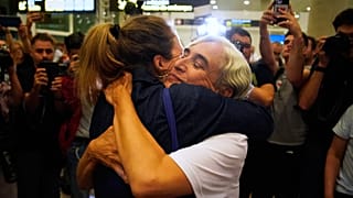 L'ex sindaca di Barcellona Ada Colau, a destra, viene abbracciata dagli amici all'arrivo all'aeroporto