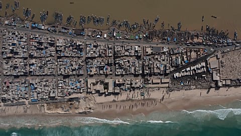 In this drone image, houses lay between the Senegal river, top, and the Atlantic Ocean beach that has been affected by erosion in Saint Louis, Senegal.