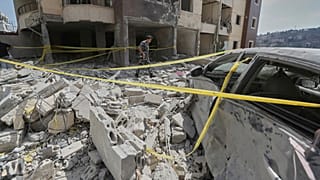 شرطي يتفقد الأضرار في مبنى أصيب بغارة إسرائيلية في بلدة النبطية جنوب لبنان، مساء الاثنين 16 سبتمبر 2025.
