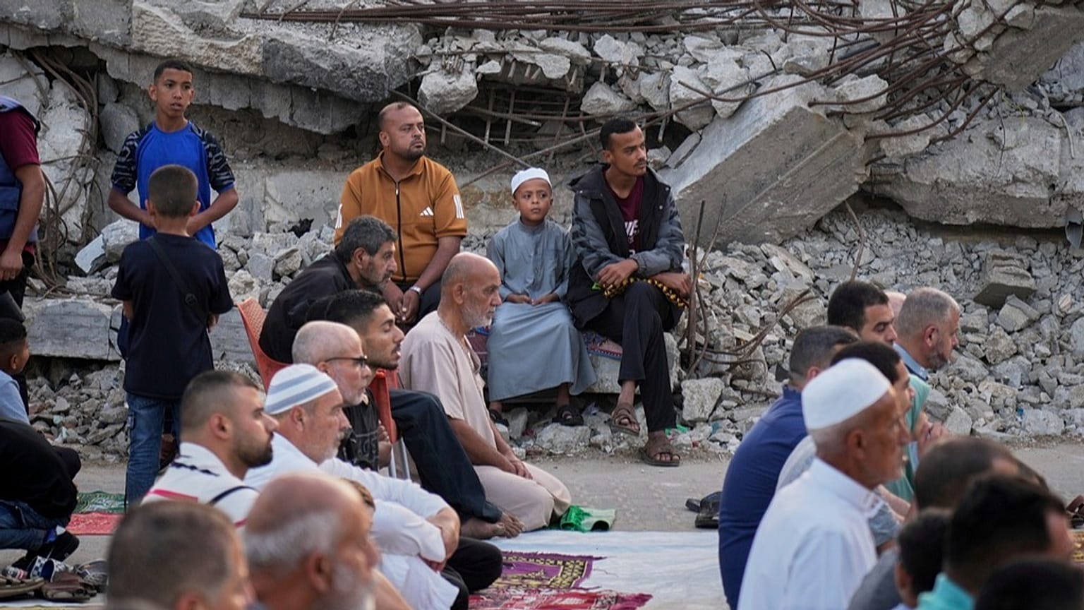 فلسطينيون يؤدّون صلاة عيد الأضحى قرب أنقاض مسجدٍ دمّرته الغارات الإسرائيلية في دير البلح وسط غزة، الجمعة 6 يونيو 2025.