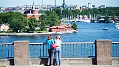 Touristen schauen auf eine Ansicht von Stockholm am 2. Juli 2015.