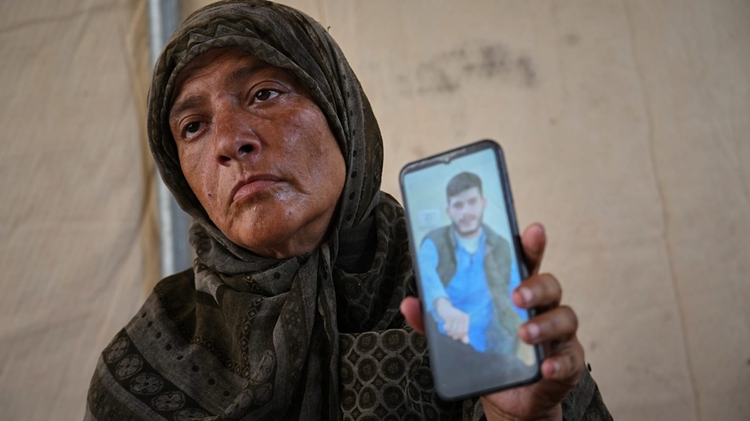 فدوى الغلبان، والدة أحد المفقودين، تحمل صورة ابنها مصعب في خيمتها في مواصي خان يونس 3 أكتوبر 2025