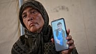 فدوى الغلبان، والدة أحد المفقودين، تحمل صورة ابنها مصعب في خيمتها في مواصي خان يونس 3 أكتوبر 2025