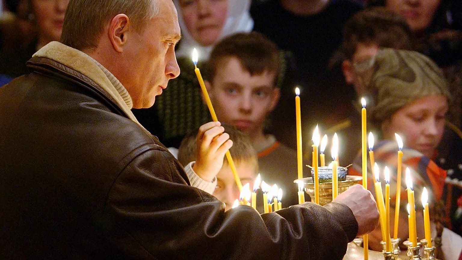 الرئيس الروسي فلاديمير بوتين يضع شمعة أثناء حضوره قدّاس عيد الميلاد في كنيسة ميلاد العذراء القديمة في مدينة غورودنْيا بمنطقة تفير، 7 كانون الثاني/يناير 2005.