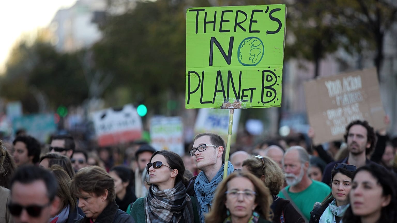 A young man carries a sign "There's no planet B" while taking part in a World Climate March in Lisbon, Sunday, Nov. 29 2015.
