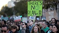 A young man carries a sign "There's no planet B" while taking part in a World Climate March in Lisbon, Sunday, Nov. 29 2015.