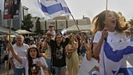 Personas reaccionan mientras se reúnen para ver la transmisión en vivo de la liberación del soldado israelí-estadounidense Edan Alexander de la cautividad de Hamas en Gaza.