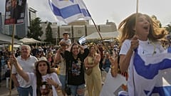 Les gens réagissent alors qu'ils se rassemblent pour regarder la diffusion en direct de la libération du soldat israélo-américain Edan Alexander, captif du Hamas à Gaza