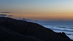 Un homme regarde le coucher de soleil sur l'océan Atlantique à la plage de La Pared sur l'île canarienne de Fuerteventura, en Espagne, lundi 6 octobre 2025. 