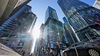People walk in Germany's main financial district between bank headquarters in Frankfurt, Germany. 9 April 2025.