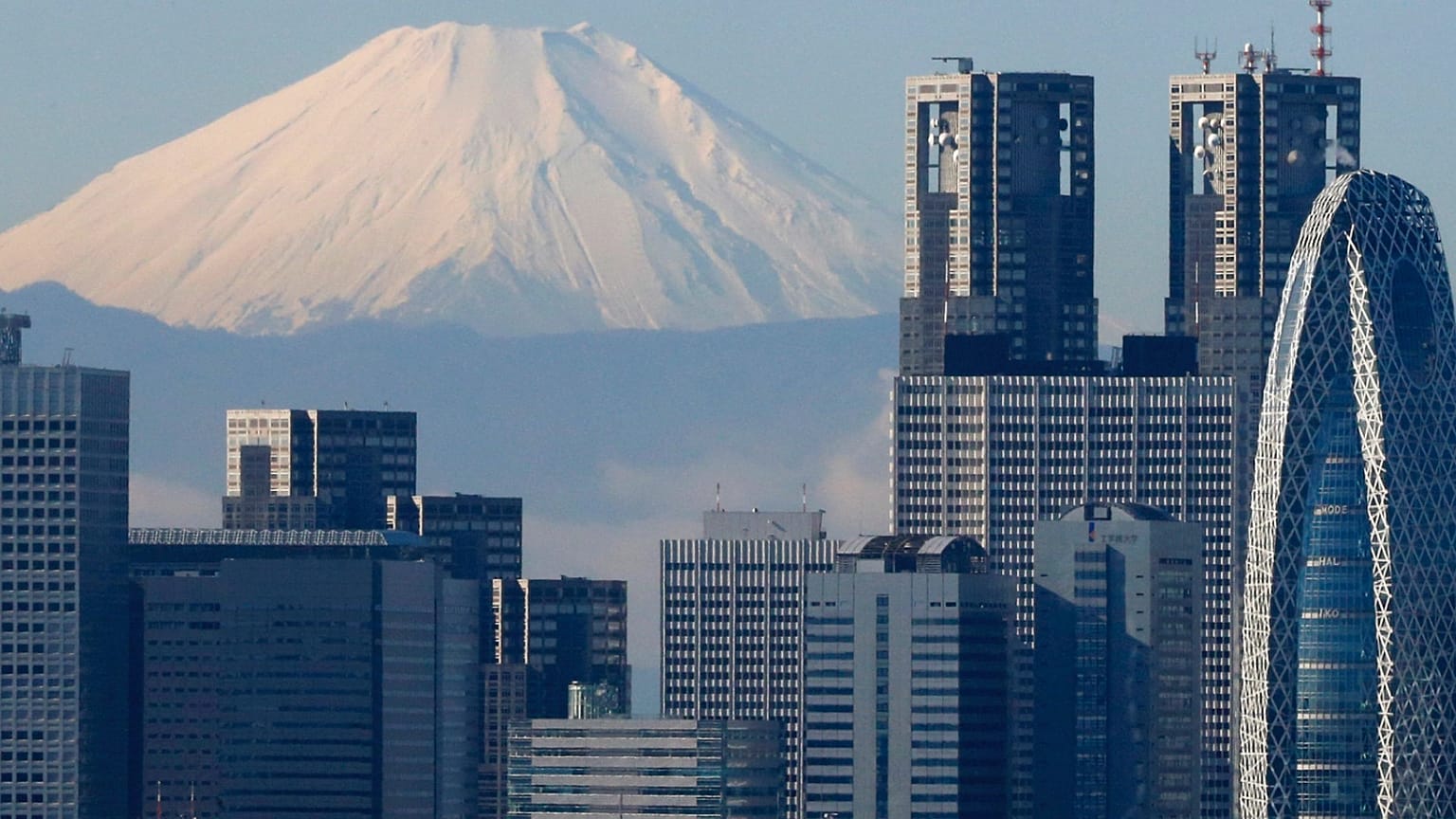 Snow-covered 3,776-meter (12,388-foot) Mount Fuji is seen behind Tokyo's skyscrapers, Japan, Thursday, Nov. 27, 2014