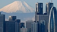 Snow-covered 3,776-meter (12,388-foot) Mount Fuji is seen behind Tokyo's skyscrapers, Japan, Thursday, Nov. 27, 2014
