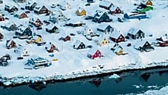 Nuuk'un bir deniz girişinin kıyısında karla kaplı evler görülüyor, 7 Mart, 2025