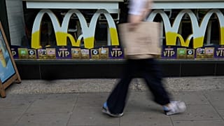 A woman walks by a McDonald's restaurant, in London, on Aug. 24, 2021.