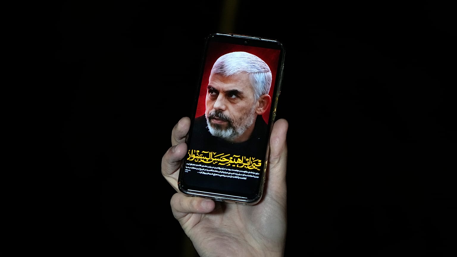 متظاهر يُظهر على هاتفه صورة لزعيم حركة حماس الراحل يحيى السنوار، طهران، يوم الخميس 16 كانون الثاني/يناير 2025. 