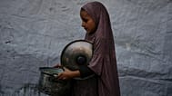 A Palestinian child carries a pot of donated food from a community kitchen in Deir al-Balah, southern Gaza Strip, on Sept. 6, 2025.
