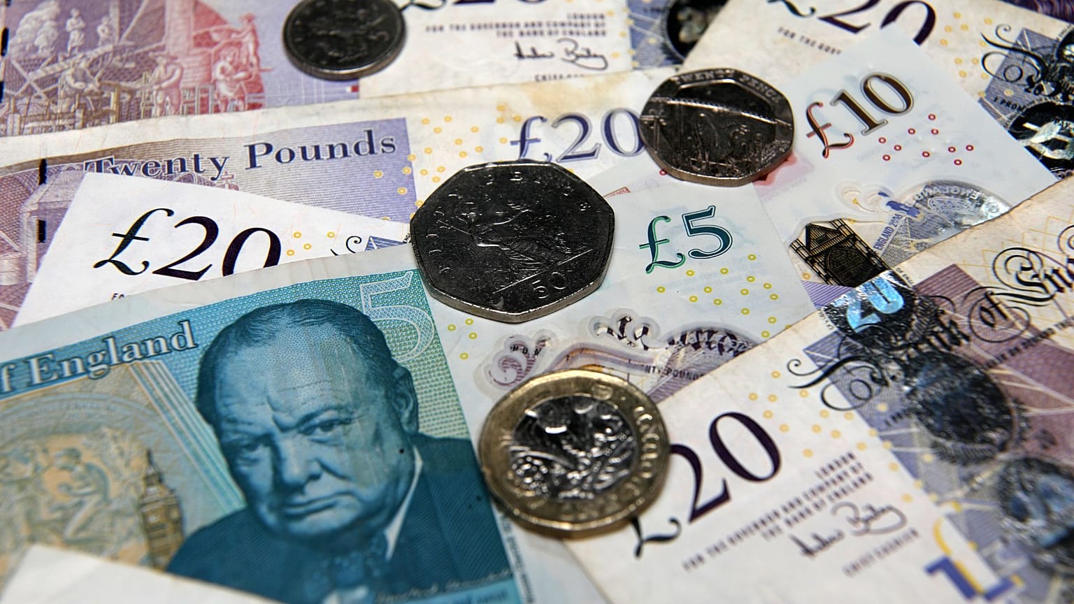 An assorted collection of UK coins and bills, illustrating the wealth gap in Britain.